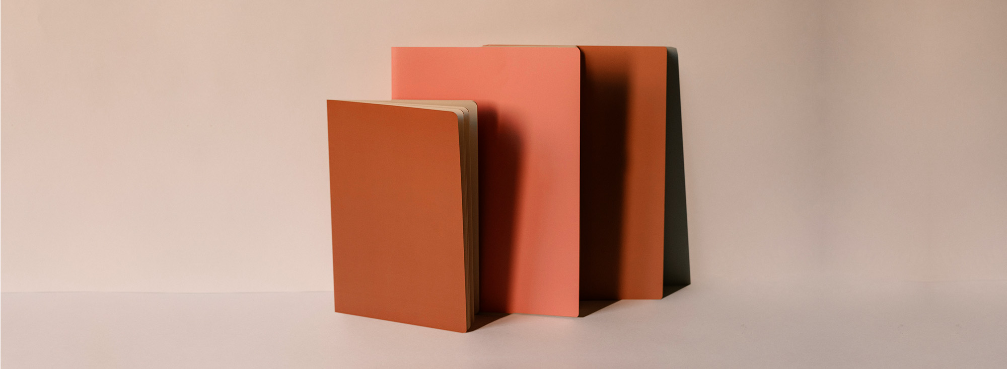 Three EtchPad notebooks lined up against a wall